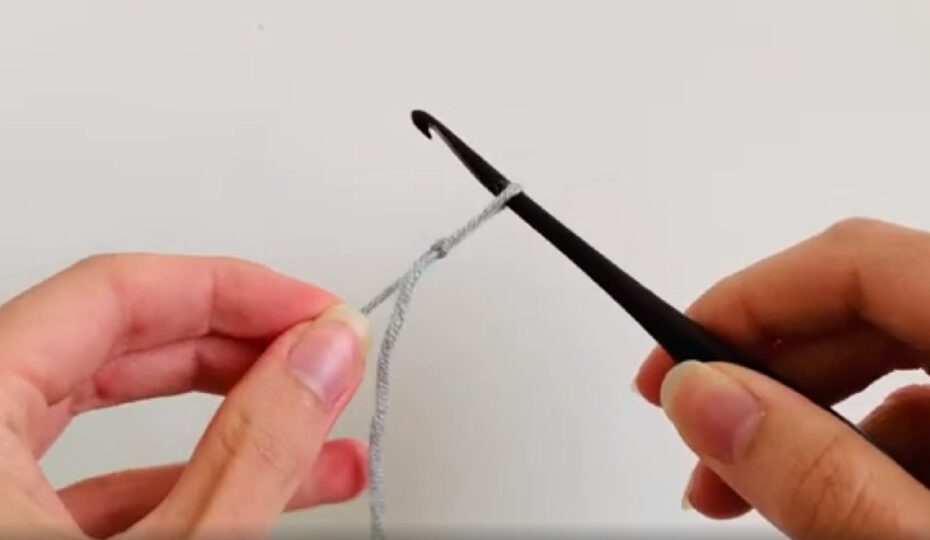 Two hands demonstrating a crochet slip knot